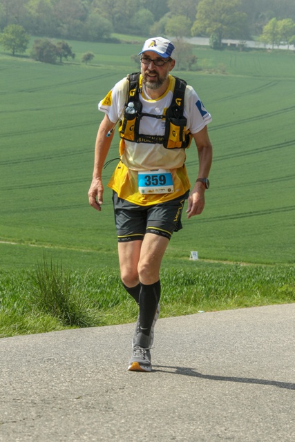Rainer Garburg beim Vulkanmarathon in Mendig. Er ist bekleidet mit dem Spendenlaufshirt und einer kurzen Laufhose. Auf dem Rücken hat er einen Laufrucksack mit Trinksystem.