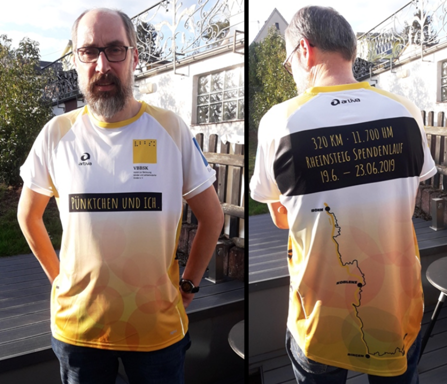 Vorn ist auf dem Shirt das Logo des Fördervereins zu sehen und ein schwarzes Textfeld mit einer gelben Schrift "Pünktchen und ich". Auf dem Rücken ist ein weiteres Textfeld mit "320km 11.700hm Rheinsteig Spendenlauf 19.6.-23.6.2019" zu sehen. Darunter eine schematische Darstellung des Rheinsteigverlaufs. Auf dem einen Ärmel befindet sich ein kreisrundes Logo des Fördervereins, auf dem anderen das Wanderzeichen des Rheinsteigs ein weißes "R" auf blauem Grund. An den Seiten steht jeweils hochkant vbbsk.de Vorn ist auf dem Shirt das Logo des Fördervereins zu sehen und ein schwarzes Textfeld mit einer gelben Schrift "Pünktchen und ich". Auf dem Rücken ist ein weiteres Textfeld mit "320km 11.700hm Rheinsteig Spendenlauf 19.6.-23.6.2019" zu sehen. Darunter eine schematische Darstellung des Rheinsteigverlaufs. Auf dem einen Ärmel befindet sich ein kreisrundes Logo des Fördervereins, auf dem anderen das Wanderzeichen des Rheinsteigs ein weißes "R" auf blauem Grund. An den Seiten steht jeweils hochkant vbbsk.de