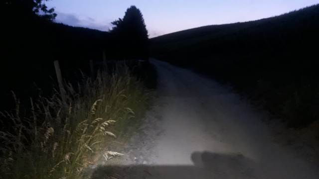 In der Dunkelheit erhellt eine Stirnlampe und eine kleine Handlampe den Weg und helfen, die Markierungen zu finden.