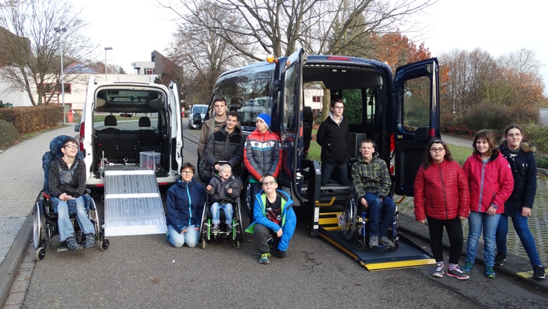 Eine Gruppe Schüler*innen vor den beiden neuen Fahrzeugen Opel Combo und Ford Transit.