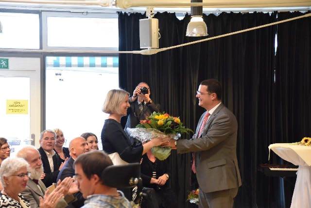 Frau Schubert bekommt zur Begrüßung einen Strauß Blumen überreicht.