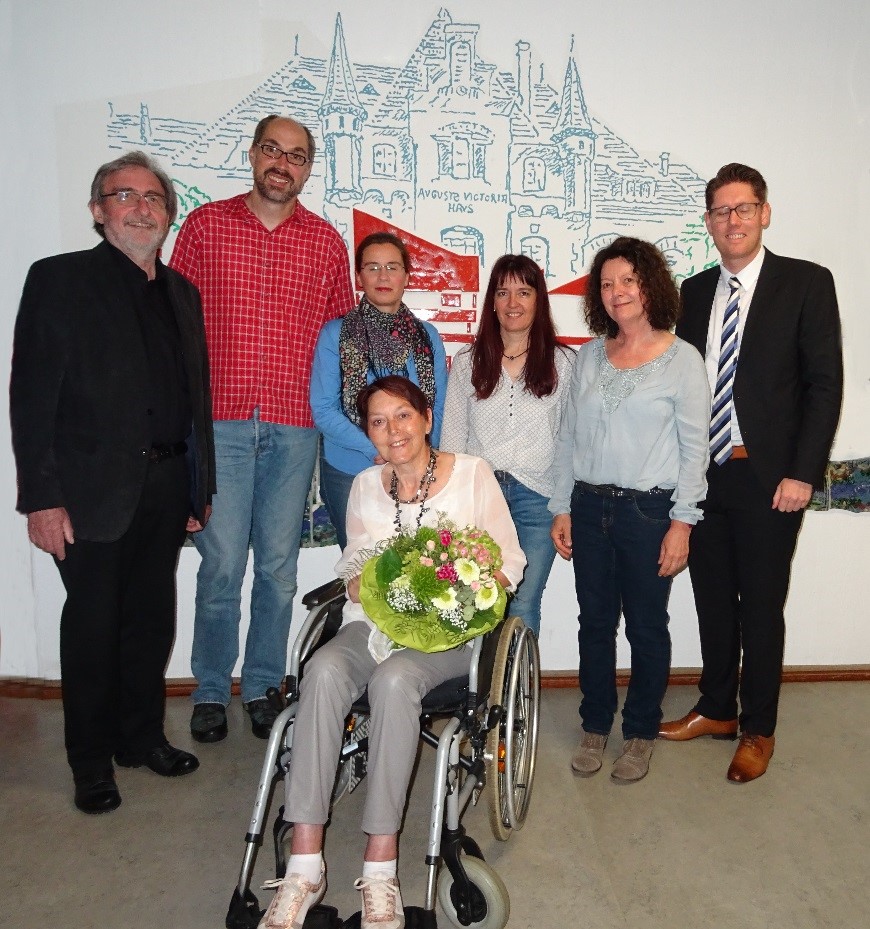Gruppenbild des neugewählten Vorstands zusammen mit der Ehrenvorsitzenden Petra Heinz. Von links nach rechts: 1. Kassenwart Karl-Ludwig Küster, 2. Schriftführer Rainer Garburg, 1. Schriftführerin Sina Miethig, 2. Kassenwartin Melanie Hanisch, 1. Vorsitzende Irene Klank-Wirbelauer, 2. Vorsitzender Daniel Hilland. Vorne sitzend: Ehrenvorsitzende Petra Heinz mit Blumenstrauß.